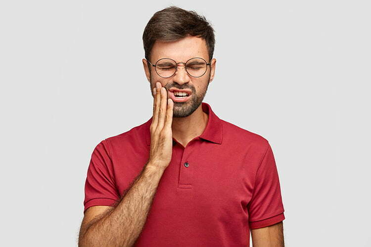 bild zeigt mann mit zahnschmerzen